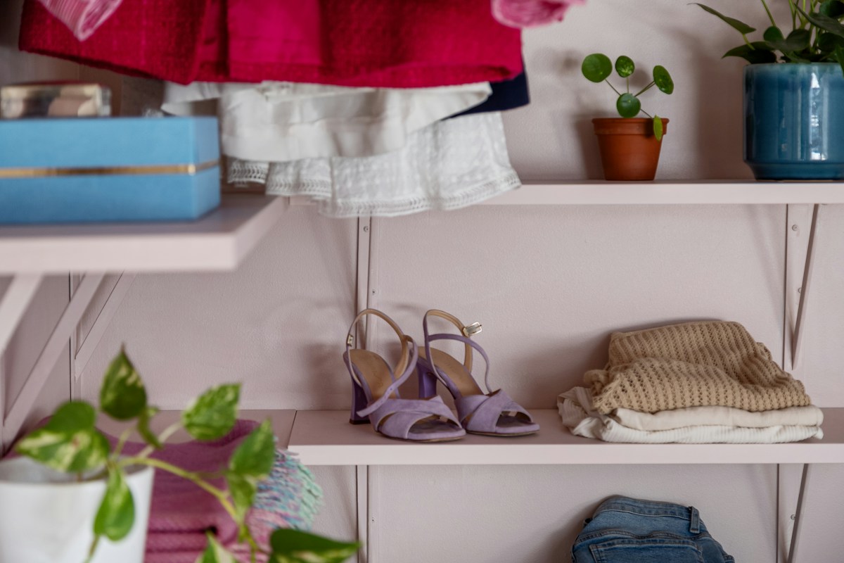 Étagère de vêtements, chaussures violettes, plantes et pulls pliés